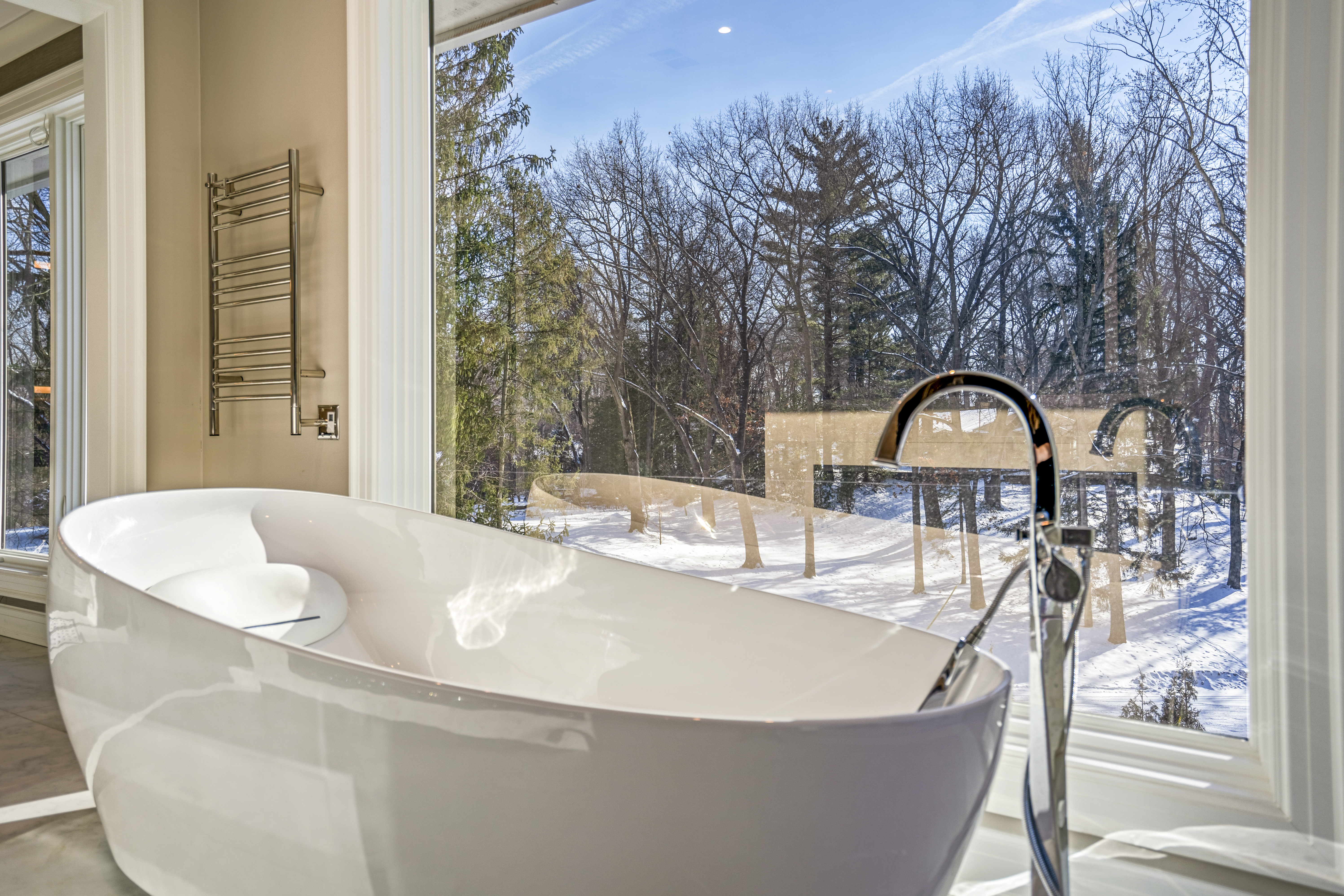 Freestanding soaking tub with winter nature view